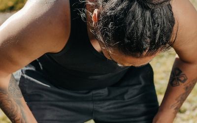 Man taking a deep breath during a resting phase of a workout.